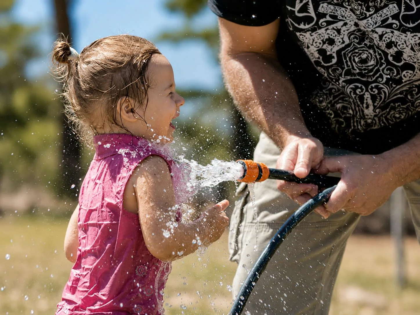 Toddler playing in hose water at Lat Wai